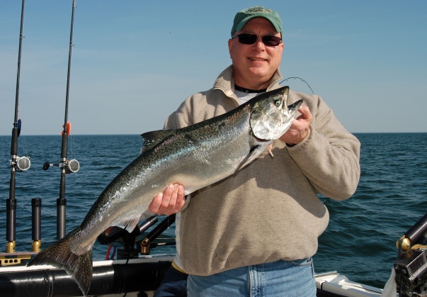 Jeff Jones, from Columbia MO., holds up a nice chinook salmon he caught off St Joseph while fishing with friends on an annual Lake Michigan salmon fishing trip. Photo: Howard Meyerson.